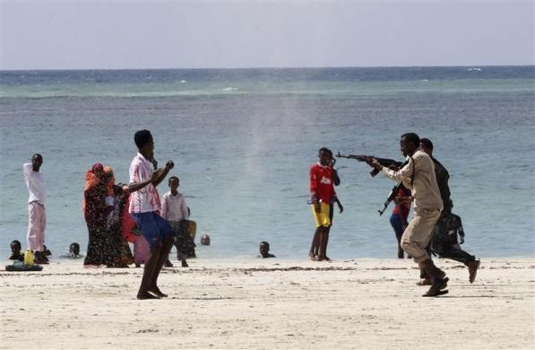 Cảnh sát Somalia (phải) bắt giữ một người đàn ông bị tình nghi là thành viên chi nhánh al Shabaab của Al Qaeda trên bãi biển Lido.
