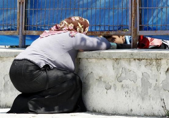 Một phụ nữ Thổ Nhĩ Kỳ trò chuyện với người thân của mình là một người tị nạn Syria qua hàng rào của trại tị nạn ở Yayladagi, tỉnh Hatay, Thổ Nhĩ Kỳ ngày 19/6/2011.