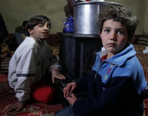 Trẻ em tị nạn Syria bỏ trốn khỏi thành phố Homs ngồi quanh bếp trong cuộc phỏng vấn với phóng viên Reuters tại một ngôi nhà tạm ở thị trấn Aarsal, Bekka, miền đông Lebanon ngày 8/12/2011.