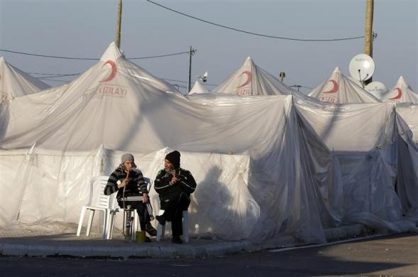 Những người đàn ông Syria đang hút shisha khi trò chuyện bên ngoài lều của mình tại trại tị nạn Boyuyogun, tỉnh Hatay ngày 18/3/2012.