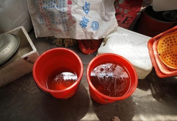 Hai xô nước tiểu được thu thập từ một trường tiểu học trong vùng đặt bên trong một gian hàng bán trứng luộc nước tiểu trẻ em tại Dongyang, Chiết Giang ngày 26/3/2012