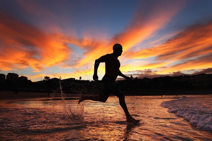 Vận động viên bơi lội chạy trên bãi biển Bondi, Sydney, Úc ngày 27/3.