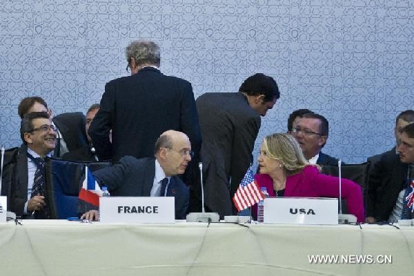 Ngoại trưởng Pháp Alain Juppe (trái) trò chuyện với Ngoại trưởng Mỹ Hillary Clinton tại Hội nghị. Ảnh Xinhua