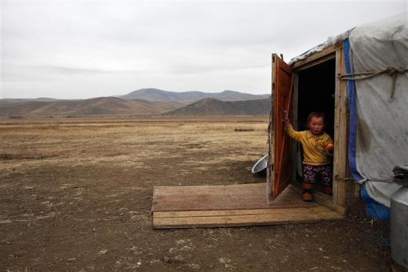 Bé Jugderdem, 2 tuổi, đứng trước cửa lều của gia đình tại Shivert, cách phía bắc Ulan Bator khoảng 200 km ngày 12/10/2011.