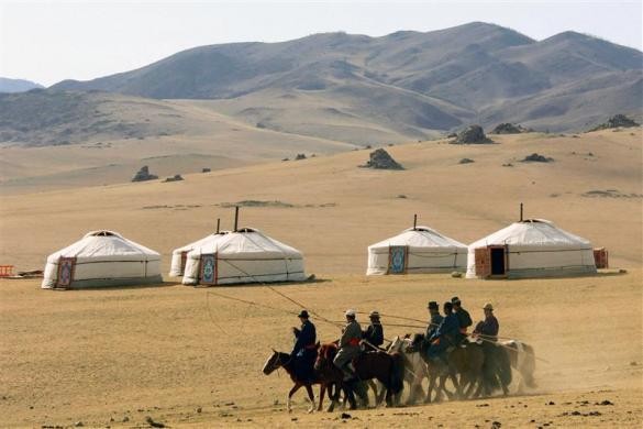 Kỵ binh Mông Cổ đi qua khu lều truyền thống được gọi là "ger" trên thảo nguyên Orkhon gần Kharkorin, cách Ulan Bator khoảng 310 km về phía tây ngày 26/5/2005.