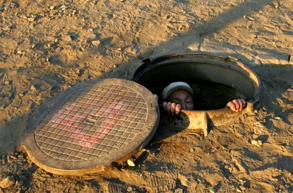 Một người Mông Cổ vô gia cư chui lên từ đường ống dẫn nhiệt ở thủ đô Ulan Bator ngày 23/11/2005.