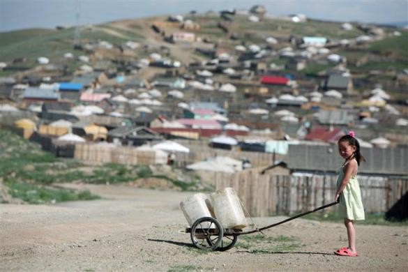 Bé gái Mông Cổ đẩy xe cút kít chở nước ngọt về nhà tại huyện Gers, Ulan Bator ngày 4/7/2006.