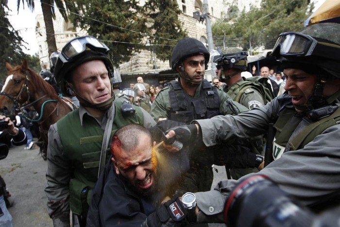 Cảnh sát Israel xịt hơi cay vào một người biểu tình Palestine bị thương trong cuộc đụng độ bên ngoài thành phố cổ Damascus Gate của Jerusalem ngày 30/3.