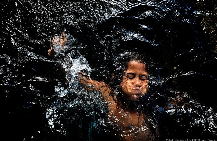 Một bé gái thưởng thức dòng nước mát chảy ra từ một đường ống hỏng ở Baucau, Timor-Leste.