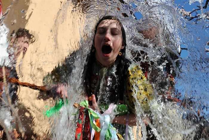 Một bé gái trong trang phục truyền thống úp mặt xuống xô nước như là một nghi thức trong lễ Phục Sinh được tổ chức tại làng Trencianska Tepla, Slovakia ngày 9/4. Nghi thức này tượng trưng cho tuổi trẻ, sức khỏe và vẻ đẹp của mùa xuân.