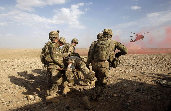 Lính Mỹ khiêng một đồng đội bị thương tới chỗ trực thăng trong thời gian diễn ra một cuộc đụng độ với lực lượng Taliban tại huyện Maiwand, tỉnh Kandahar, nam Afghanistan ngày 9/4.