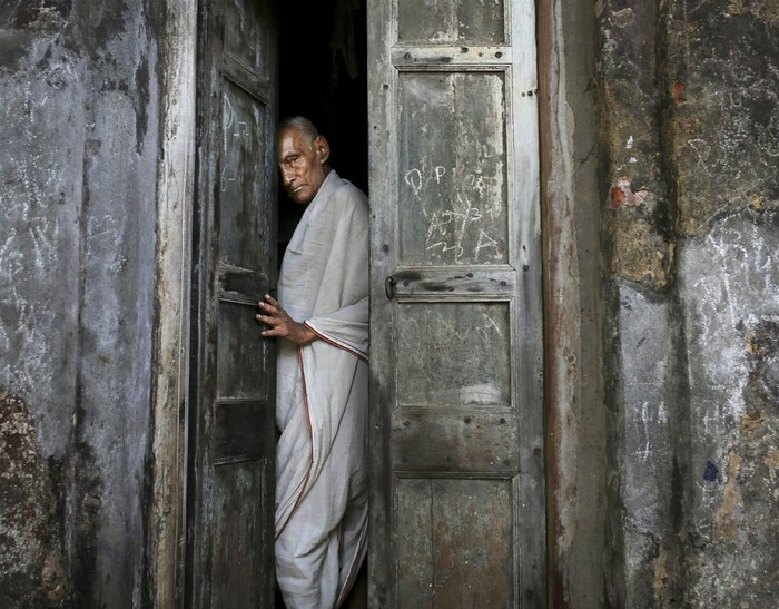 Một người đàn ông đang chuẩn bị đóng cửa nhà trong một con hẻm gần ngôi đền Kali tại thành phố Kolkata, miền đông Ấn Độ ngày 14/4.