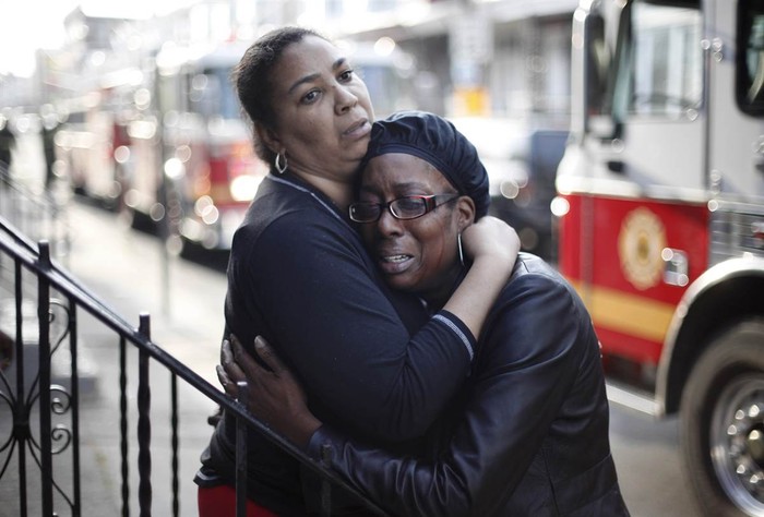 Debra Forrest (phải) trong vòng tay của một người phụ nữ đang cố an ủi cô sau khi hỏa hoạn khiến một người thân trong gia đình Debra thiệt mạng tại Philadelphia (Mỹ) ngày 16/4.