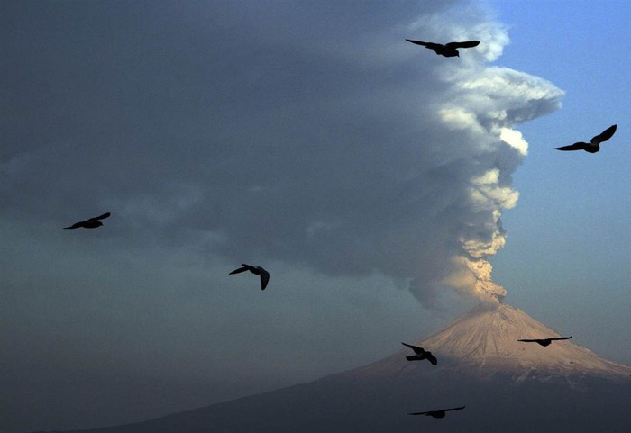 Đàn chim bay lượn gần miệng núi lửa Popocatepetl đang phun tro bụi và hơi nước được nhìn thấy từ San Andres Cholula, Mexico, ngày 18 tháng 4.