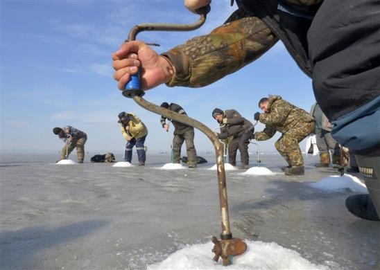 Ngư dân khoan lỗ băng câu cá tại thành phố viễn đông Vladivostok của Nga ngày 19/2/2012.