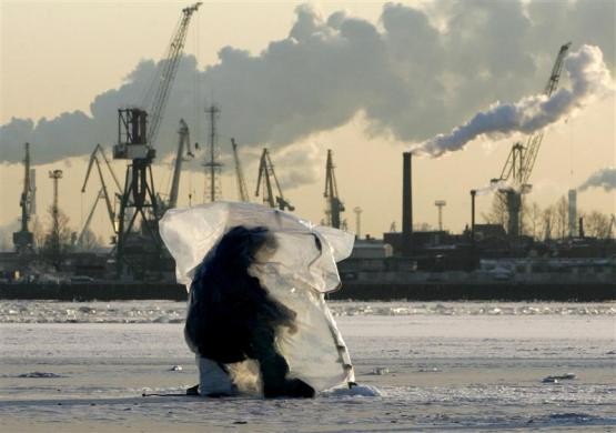 Một người đàn ông dùng nilon để tự vệ trước băng giá khi câu cá trên băng tại cảng St Petersburg, vịnh Phần Lan, Nga ngày 21/1/2006.