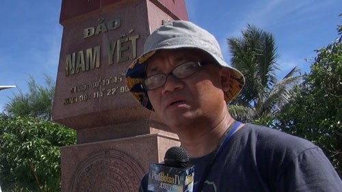 Nhà báo Việt kiều Mỹ Vũ Hoàng Lân bên mốc chủ quyền trên đảo Nam Yết - Ảnh: Phố Bolsa TV cung cấp