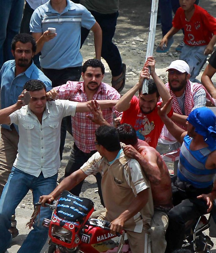 Người biểu tình Ai Cập đuổi đánh một người đàn ông ngồi sau chiếc xe máy bị buộc tội tấn công người biểu tình tại quận Abbassiya, Cairo ngày 2/5.