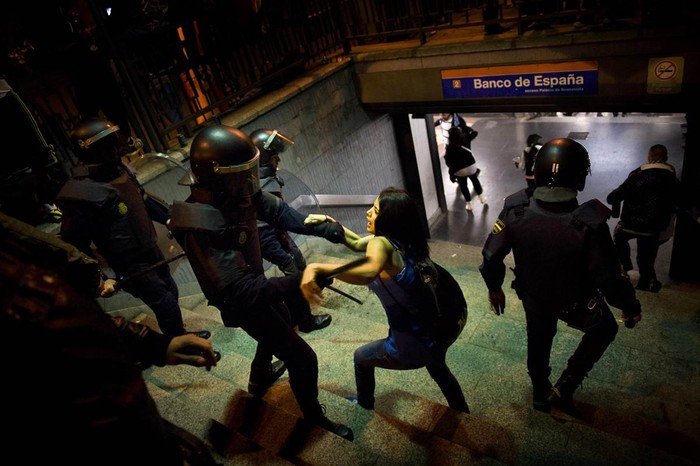 Các nhân viên cảnh sát bắt giữ một cô gái tham gia lễ kỷ niệm tại trạm tàu điện ngầm Ngân hàng Tây Ban Nha ở thành phố Madrid sau khi Real Madrid giành chiến thắng tại giải bóng đá Tây Ban Nha ngày 3/5.