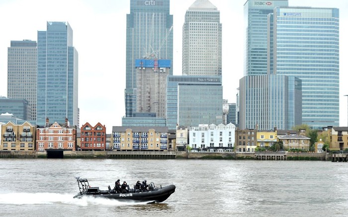 Cảnh sát London đi thuyền qua Canary Wharf trước khi tàu HMS Ocean tới sông Thames
