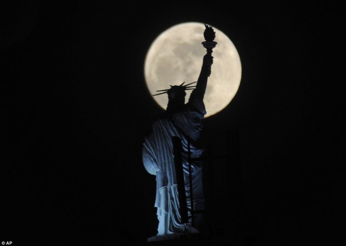 Siêu mặt trăng được nhìn thấy phía trên bức tượng Nữ thần tự do được nhìn từ một khách sạn ở thủ đô Pristina, Kosovo.