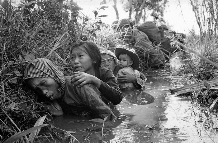 Phụ nữ và trẻ em Việt Nam cúi mình nấp dưới một con kênh đầy bùn cách phía tây Sài Gòn khoảng 20 dặm vào tháng 1/1966.