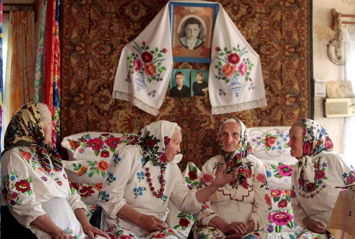 Những người phụ nữ mặc trang phục truyền thống trò truyện trước khi tiến hành nghi thức kỷ niệm vị thần bảo vệ mùa màng Yurya trong làng Pogost, Belarus ngày 6/5.