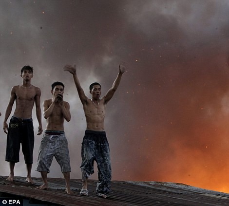 Những người mắc kẹt trong lửa đứng trên mái nhà hò hét cầu cứu.