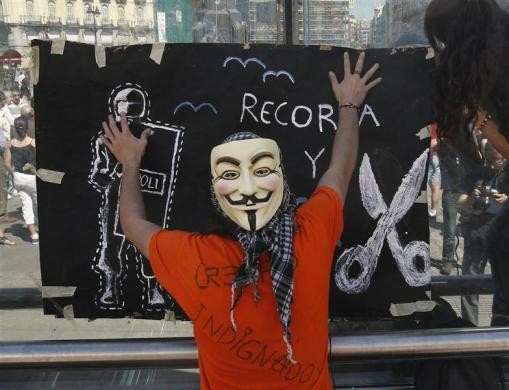 Người biểu tình mang mặt nạ giơ cao biểu ngữ "Cắt và dán" tại Madrid ngày 13/5.