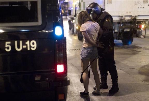 Một phụ nữ tham gia biểu tình bị bắt giữ tại Madrid ngày 13/5.