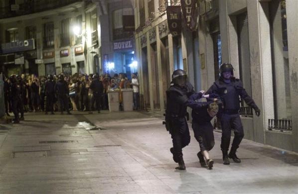 Cảnh sát bắt giữ người biểu tình quá khích hôm 13/5 tại Madrid.