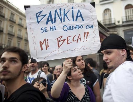 Người biểu tình giơ tấm biểu ngữ "Bankia - học bổng của tôi" tại quảng trường Puerta del Sol nhân kỷ niệm 1 năm thành lập phong trào biểu tình Indignados tại Madrid ngày 12/5.