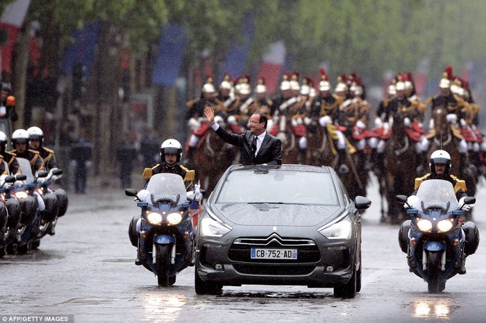 Ông Hollande đáp lại sự chào đón của đám đông người dân tập trung ven đường khi diễu hành qua đại lộ Champs-Elysee