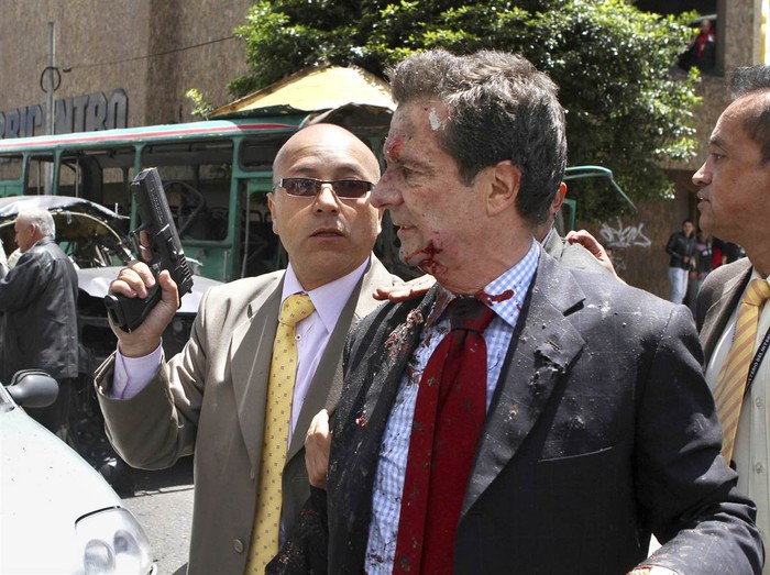 Cựu Bộ trưởng Bộ Nội vụ Colombia, Fernando Londono, được hộ tống bởi một vệ sĩ sau khi ông bị thương trong một vụ nổ tại trung tâm Bogota ngày 15/5.