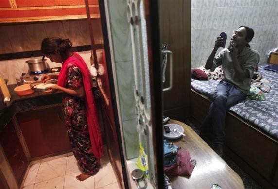 Seema nhổ râu cằm trong khi vợ anh đang chuẩn bị nấu bữa trưa tại nhà riêng của họ ở New Delhi ngày 14/5/2012.