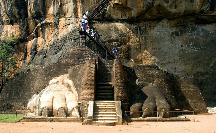 Khách du lịch đi trên bậc thang dẫn lên công trình kiến trúc cổ xưa được xây dựng phục vụ các tín đồ Phật giáo.
