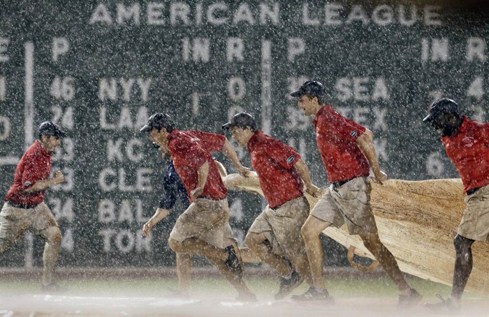 Các nhân viên mang tấm phủ lên sân bóng chày trong hiệp 8 của trận đấu giữa đội Boston Red Sox và Detroit Tigers tại sân Fenway Park ở Boston, Massachussett, Mỹ ngày 29/5.