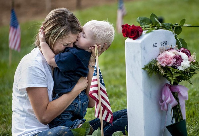Brittany Jacobs và cậu con trai 17 tháng tuổi Christian ôm nhau trước mộ của người chồng Christopher Jacobs tại nghĩa trang Arlington National Cemetery ở Arlington, Virginia, Mỹ trong "Ngày tưởng niệm".