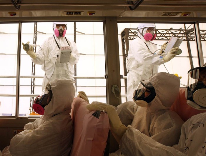 Các nhân viên kỹ thuật kiểm tra nồng độ phóng xạ trong một chiếc xe bus tại Fukushima ngày 26/5.
