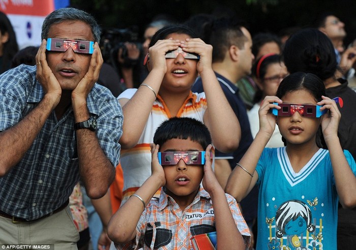 Một gia đình Ấn Độ ở New Delhi sử dụng kính đặc biệt để xem sao Kim đi qua Mặt trời