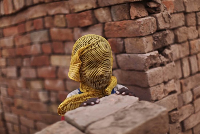 Một cậu bé Pakistan sống gần một nhà máy gạch tại Islamabad, Pakistan dùng khăn bịt mặt để tránh bão cát ngày 6/6.