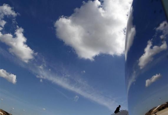 Tổng thống Obama bước lên cầu thang dẫn lên chiếc Không lực 1 tại căn cứ Andrews bên ngoài Washington trước khi khởi hành đến San Francisco, ngày 06 tháng 6 năm 2012. Những đám mây được phản chiếu trên động cơ của máy bay