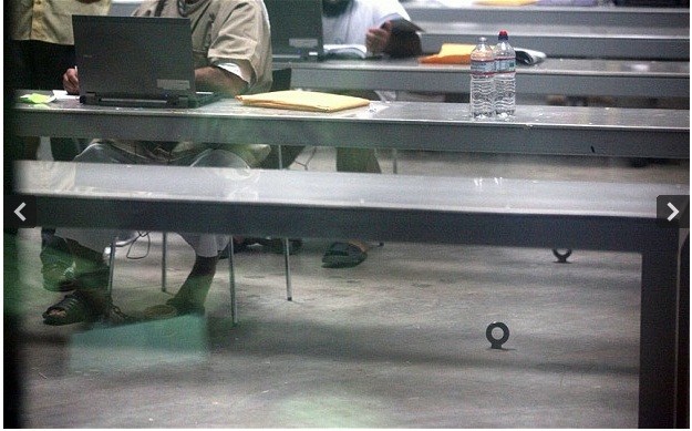 Các tù nhân bị cùm chân vào các xích sắt dưới sàn khi ngồi trong một lớp học máy tính.