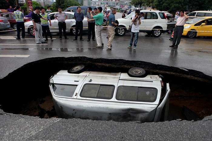 Một chiếc xe bị kẹt trong hố tử thần được tạo ra do trận mưa kéo dài tại Quế Lâm, Trung Quốc ngày 8/6.