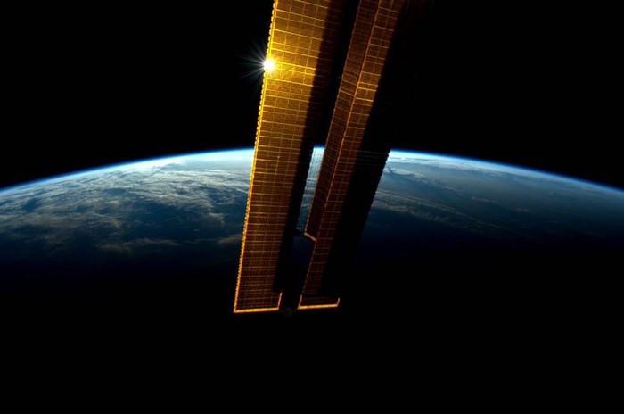 Mặt trời phản chiếu qua tấm pin mặt trời của Trạm vũ trụ quốc tế tại ranh giới giữa đêm và ngày hôm 8/6.