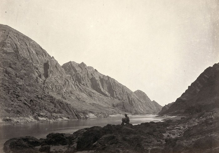 Một người đàn ông ngồi trên bờ đá cạnh sông Colorado ở Iceberg Canyon, trên biên giới của quận Mojave, Arizona, và quận Clark, Nevada vào năm 1871.