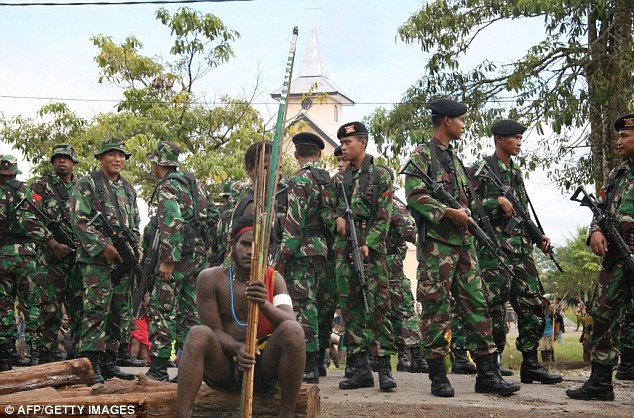 Các binh sĩ Indonesia bao quanh một chiến binh trang bị cung tên.