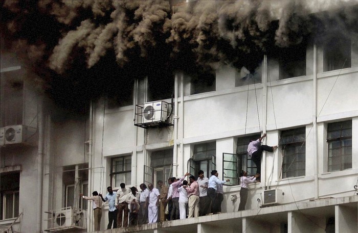 Các nhân viên tìm cách thoát khỏi tòa nhà chính phủ bốc cháy dữ dội thuộc bang Maharashtra, Ấn Độ ngày 21/6.