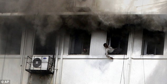 Những người đàn ông tuyệt vọng tìm cách thoát ra khỏi tòa nhà đang bốc khói nghi ngút.
