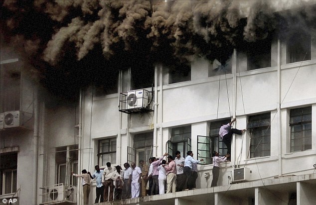 Nhiều người bị kẹt trên ban-công tòa nhà chờ lực lượng cứu hỏa tới giải cứu.